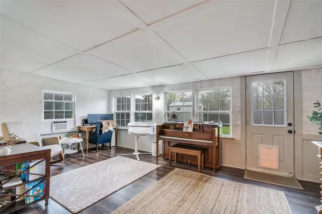 a living room with furniture a fireplace and large windows