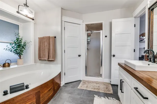 a bathroom with a tub sink and mirror