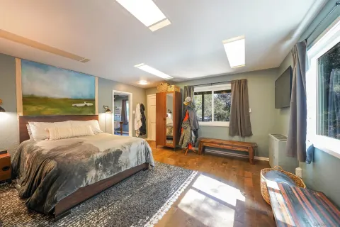 a bedroom with a bed and large windows