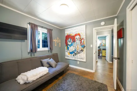 a living room with furniture and painting on the wall