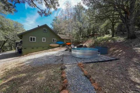 a view of a house with large trees and a big yard