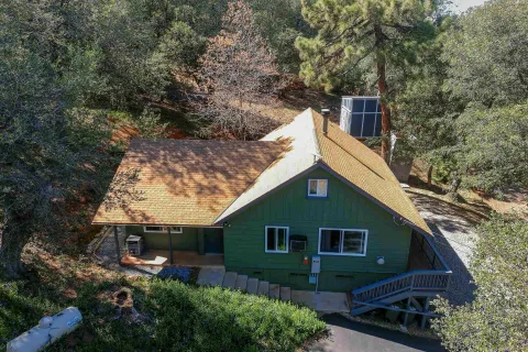 an aerial view of a house with a yard basket ball court and outdoor seating