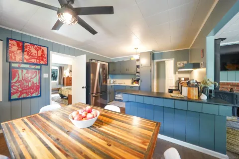 a room with stainless steel appliances kitchen island granite countertop furniture and a flat screen tv