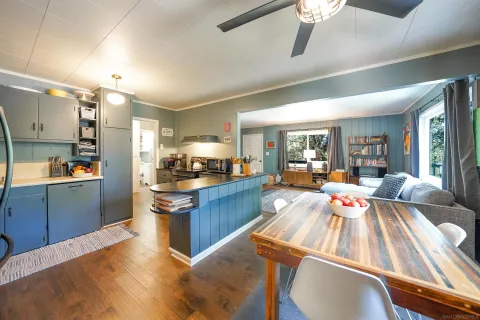 a large open kitchen with stainless steel appliances kitchen island granite countertop a refrigerator a stove and a sink dishwasher with wooden floor