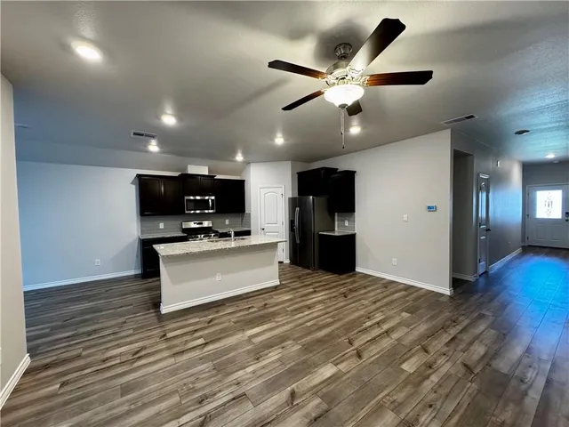 a view of kitchen with cabinets microwave and stove