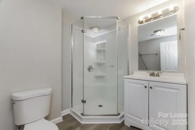 a bathroom with a shower a sink and toilet