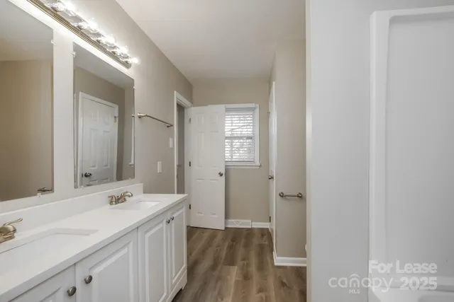 a spacious bathroom with a double vanity sink and a mirror