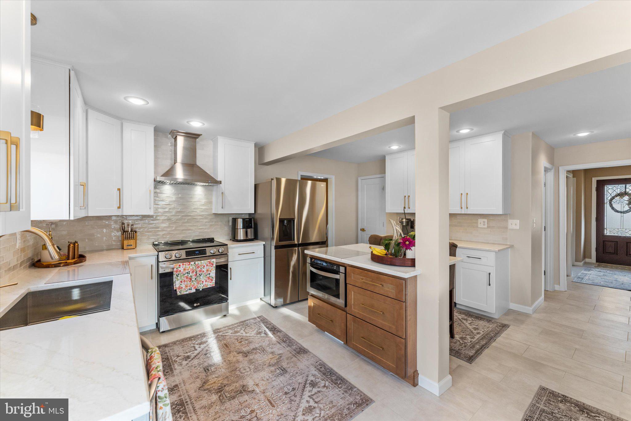8015 Stillbrooke Road Manassas, VA 20112 - Photo 4 of 34 a kitchen with refrigerator a stove and cabinets
