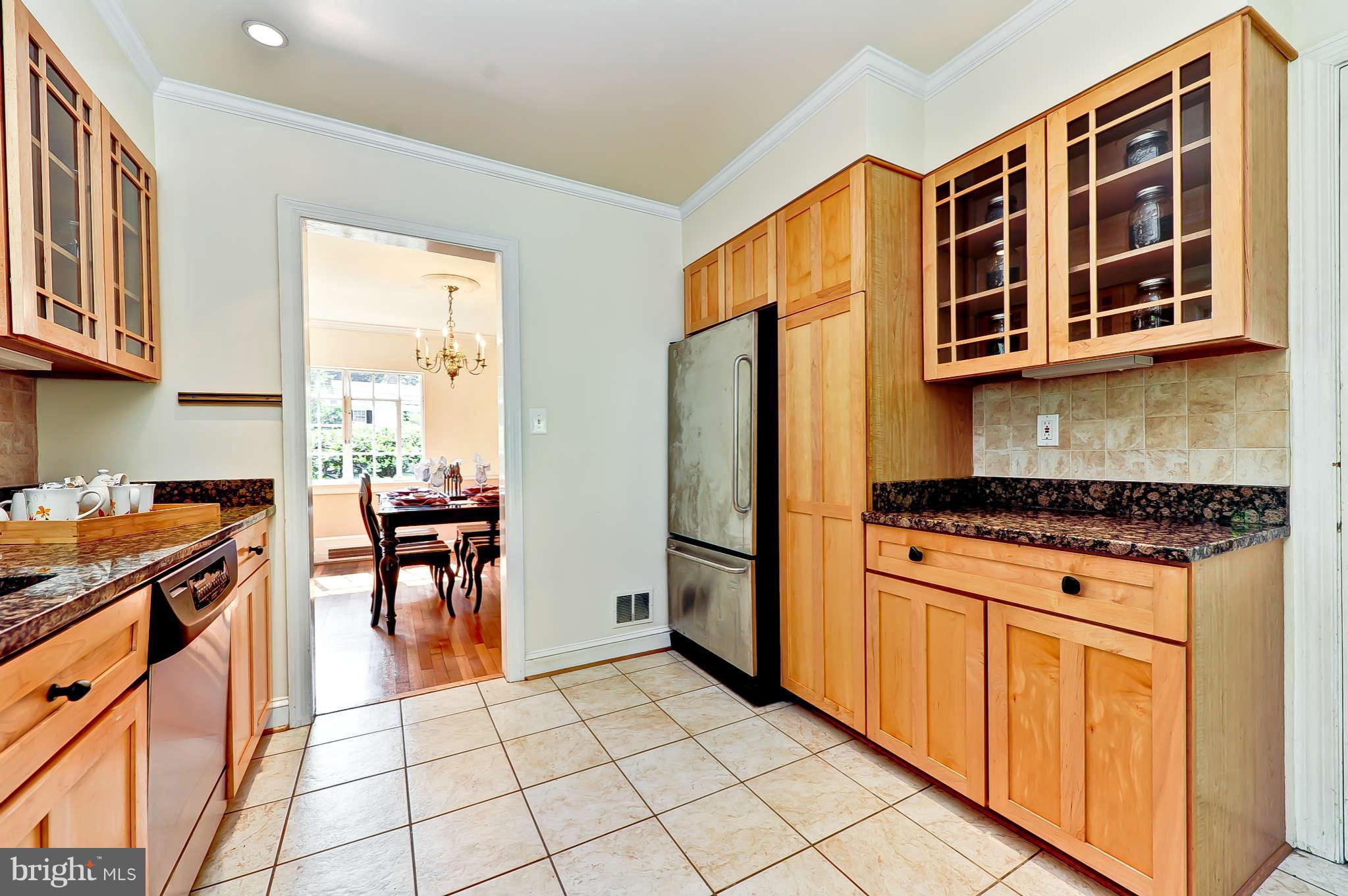 3203 Russell Road Alexandria, VA 22305 - Photo 13 of 30 a kitchen with stainless steel appliances granite countertop a stove top oven a sink a dining table and chairs with wooden floor