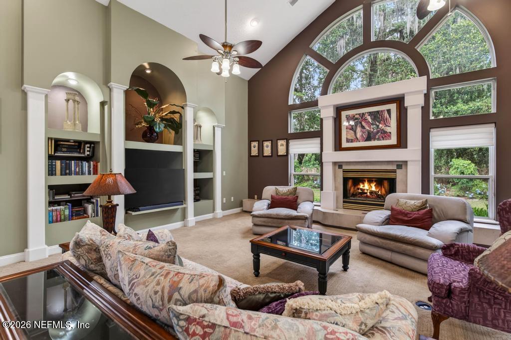 1483 Bridgette Way Fleming Island, FL 32003 - Photo 23 of 63 a living room with furniture a fireplace and a large window