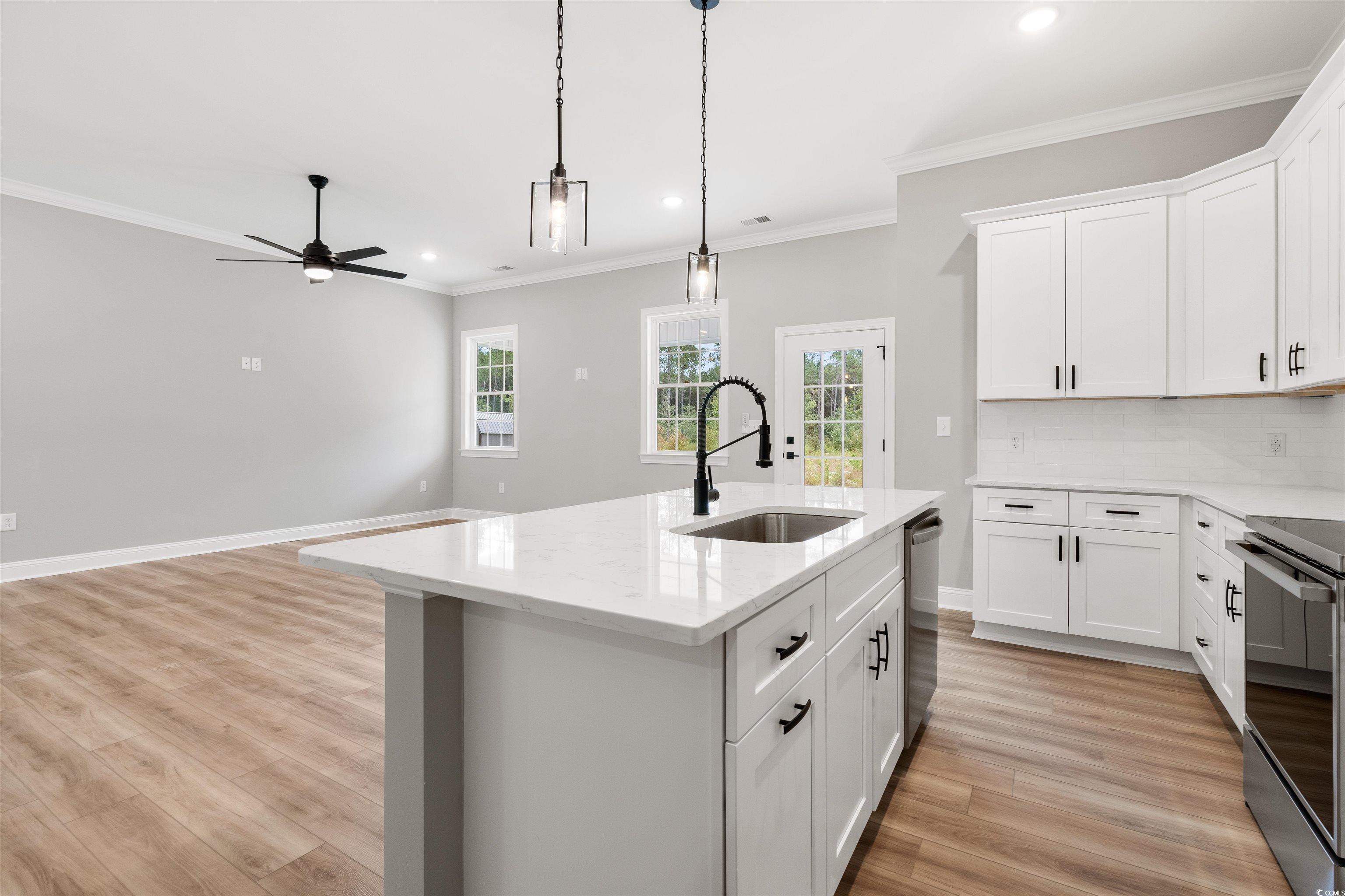 6909 Pauley Swamp Road Conway, SC 29527 - Photo 16 of 40 Kitchen with white cabinetry, appliances with stai