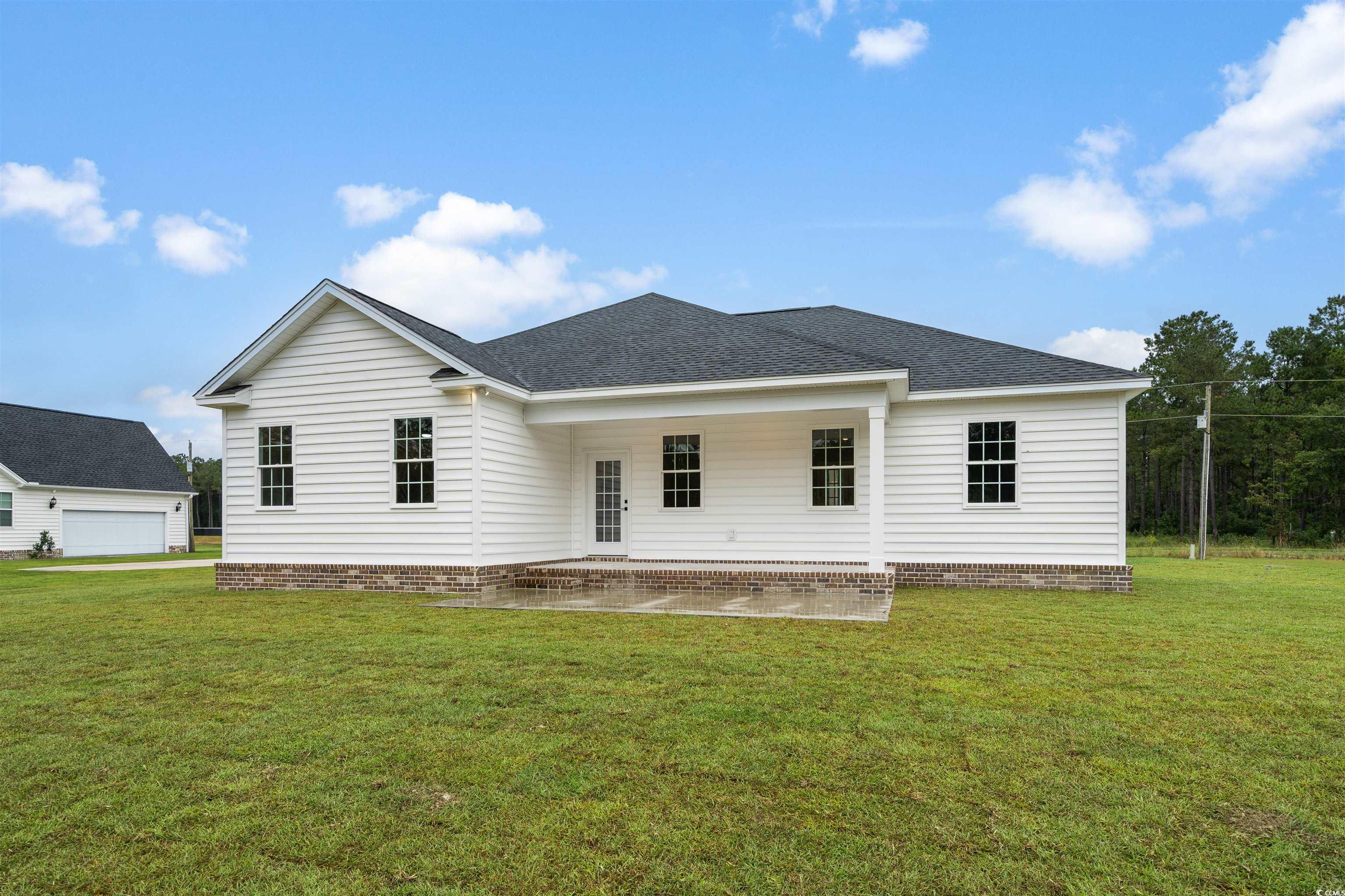 6909 Pauley Swamp Road Conway, SC 29527 - Photo 23 of 40 Back of property featuring a garage, a lawn, and a