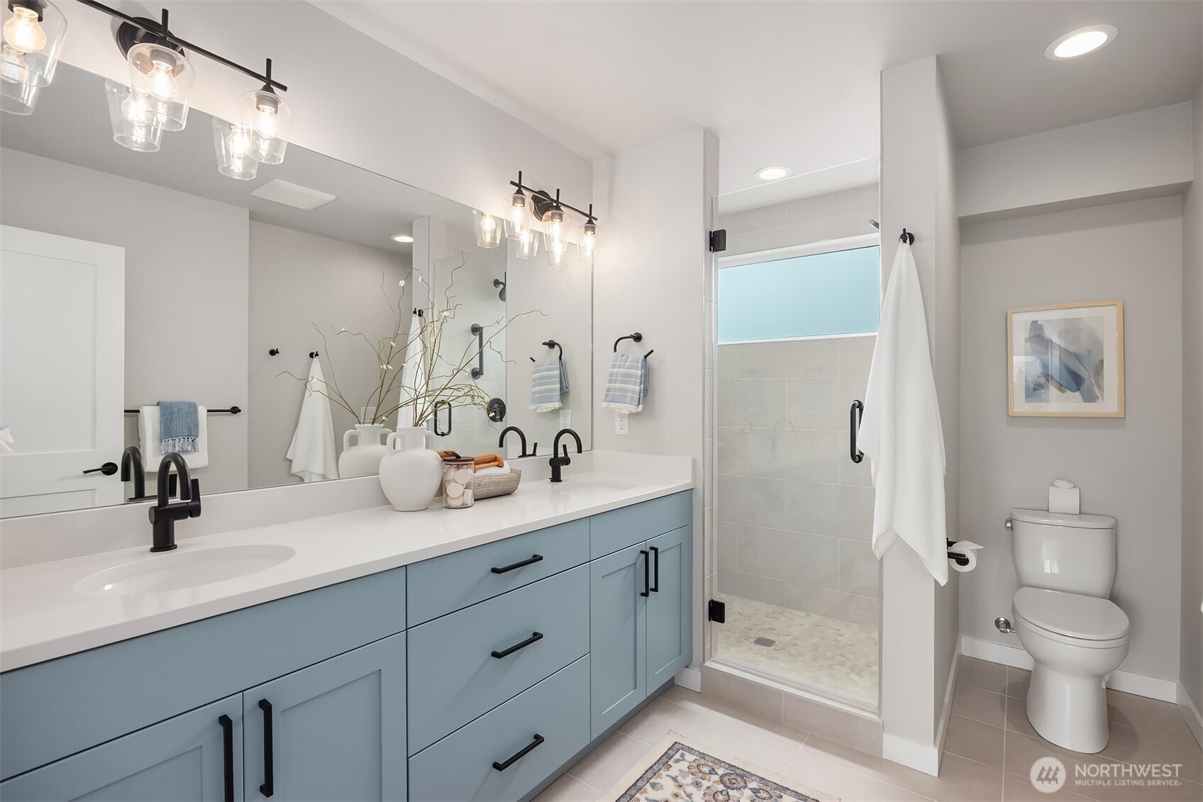 516 North 61st Street, Unit B Seattle, WA 98103 - Photo 12 of 17 a bathroom with a double vanity sink toilet mirror and shower