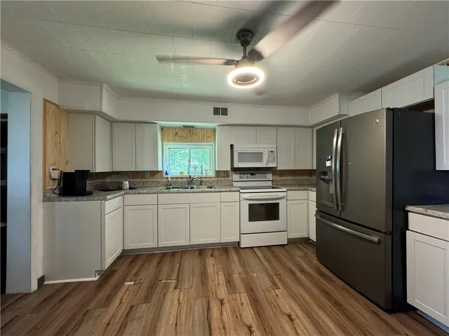 a kitchen with a refrigerator and white cabinets