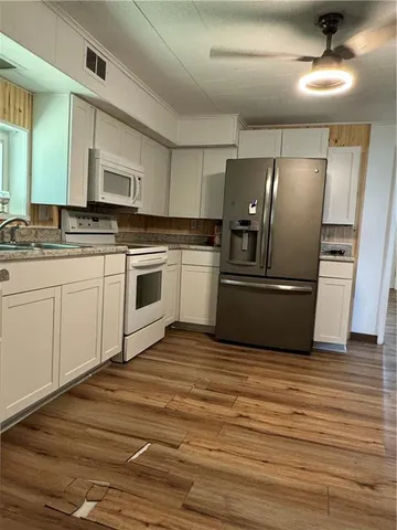 a kitchen with granite countertop a refrigerator and a sink