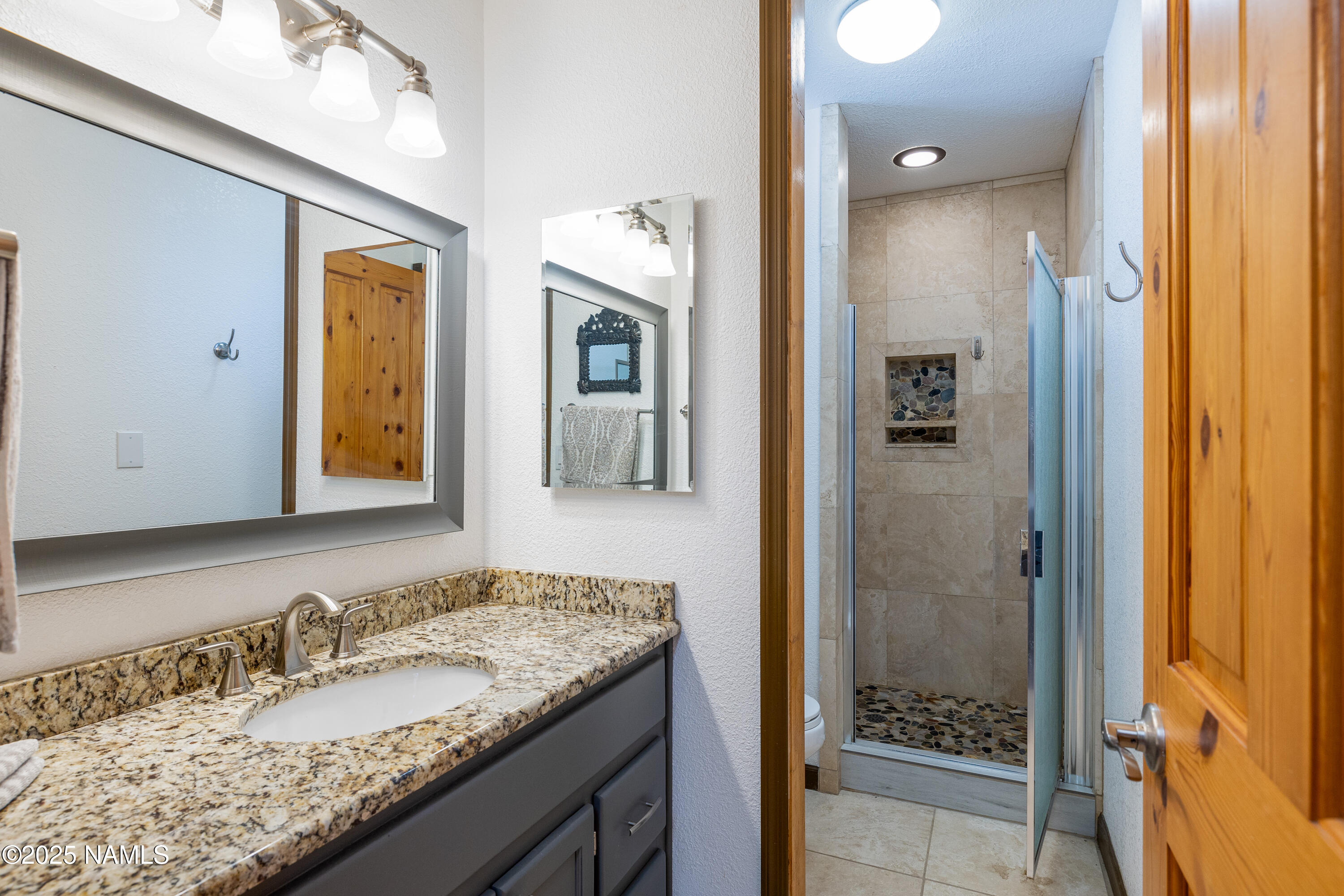 5966 East Camden Road Flagstaff, AZ 86004 - Photo 44 of 70 a bathroom with a granite countertop sink and a mirror
