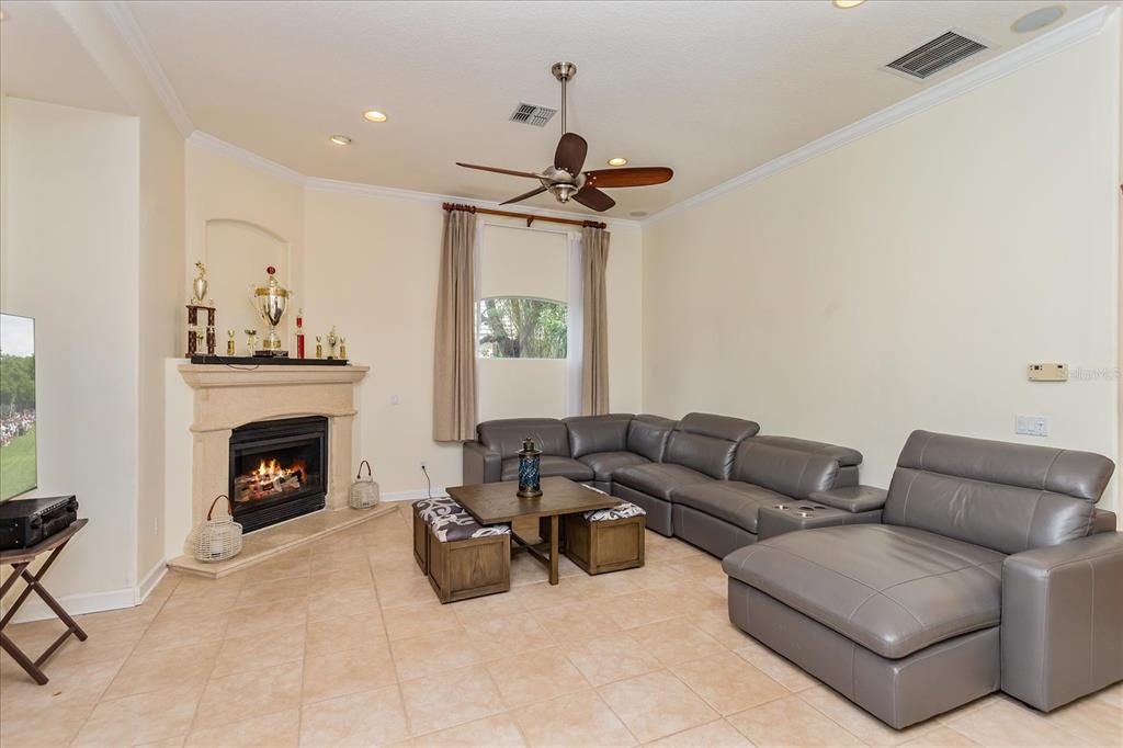 10606 Boca Pointe Drive Orlando, FL 32836 - Photo 22 of 39 a living room with furniture a fireplace and a chandelier