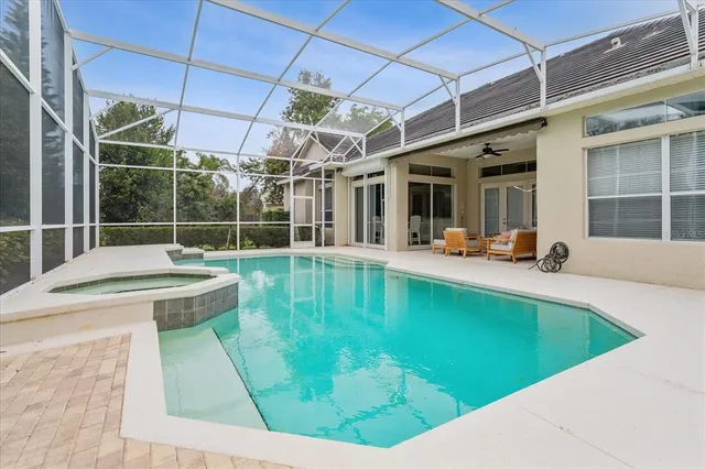 a view of a swimming pool with a patio and a yard