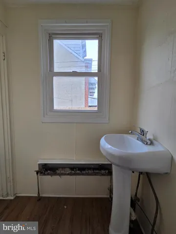 a bathroom with a sink a window and chair