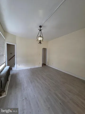 a view of a livingroom with wooden floor and a ceiling fan