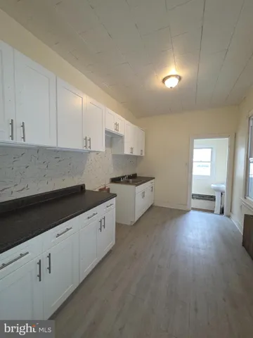 a kitchen with granite countertop white cabinets and white appliances
