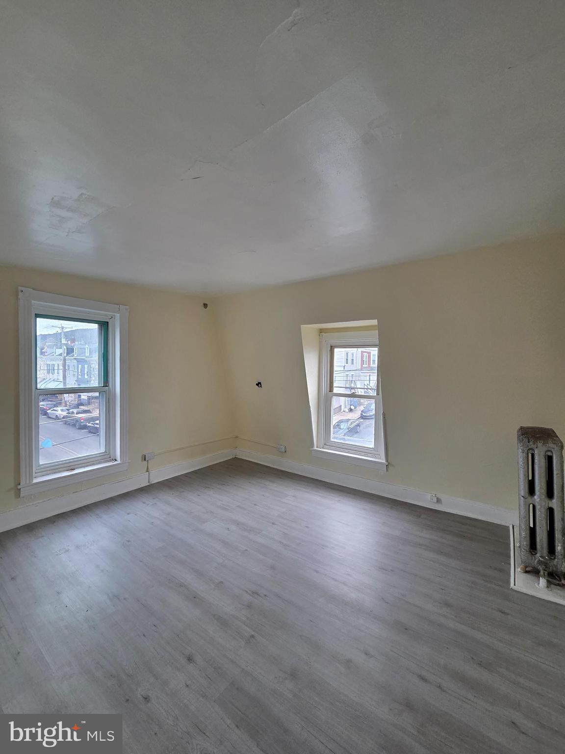 1135 Cotton Street Reading, PA 19602 - Photo 7 of 17 an empty room with wooden floor and windows