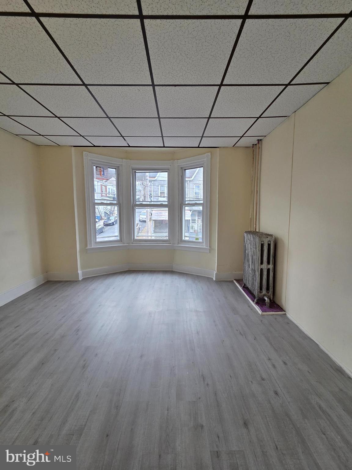 1135 Cotton Street Reading, PA 19602 - Photo 9 of 17 an empty room with wooden floor and windows