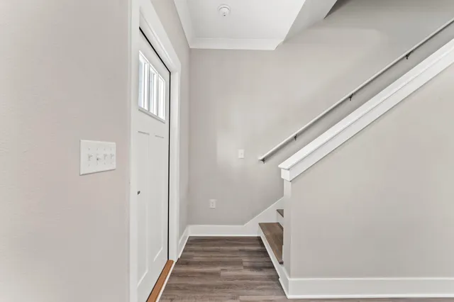 a view of a hallway with wooden floor and staircase