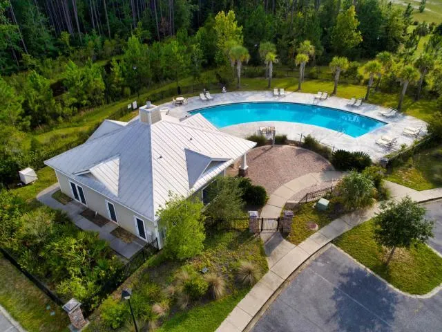 an aerial view of a house with outdoor space and swimming pool