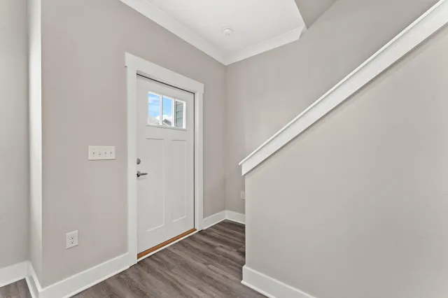a view of a hallway with wooden floor and staircase