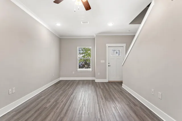 an empty room with wooden floor and windows