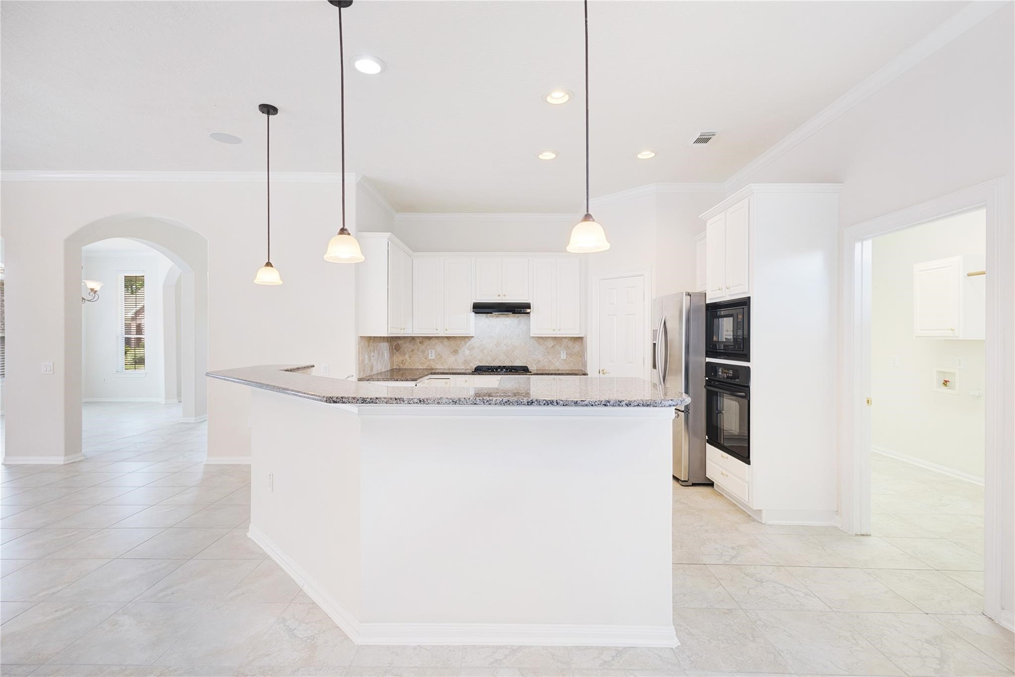 43 Tarrytown Way Conroe, TX 77384 - Photo 18 of 40 a view of a kitchen with kitchen island a counter top space a sink stainless steel appliances and cabinets