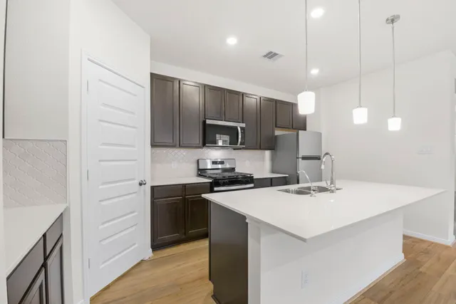 a kitchen with a sink a microwave a stove and refrigerator