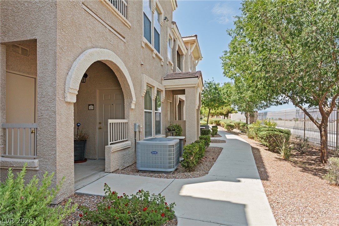 10550 West Alexander Road, Unit 1025 Las Vegas, NV 89129 - Photo 1 of 42 A welcoming front entrance, framed by mature trees, invites residents into a comfortable living space.