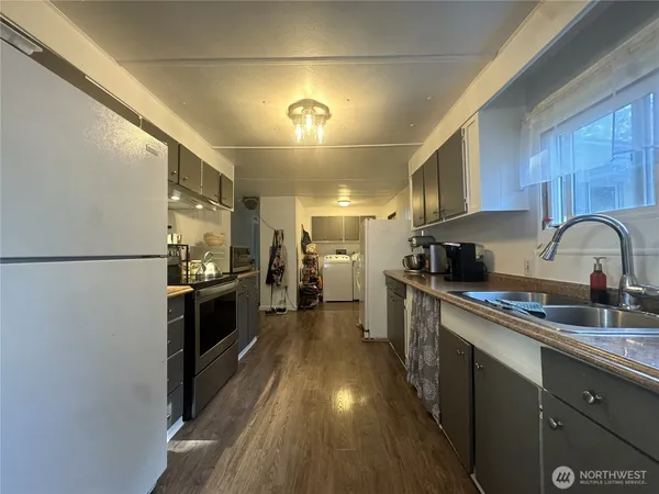 a kitchen with granite countertop a refrigerator stove and sink