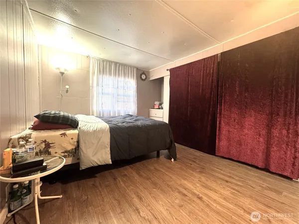 a bedroom with a bed and wooden floor