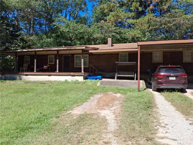 a view of a house with a backyard and sitting area