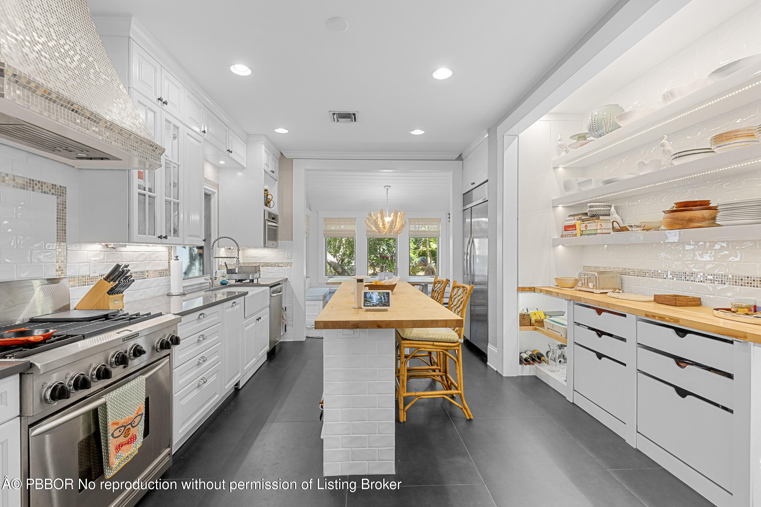 321 Croton Way West Palm Beach, FL 33401 - Photo 16 of 40 a large kitchen with kitchen island a stove a sink dishwasher and white cabinets with wooden floor