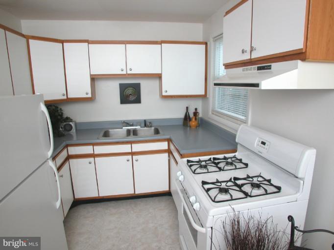 7920 Ridgely Oak Road Parkville, MD 21234 - Photo 12 of 13 a kitchen with white cabinets and appliances