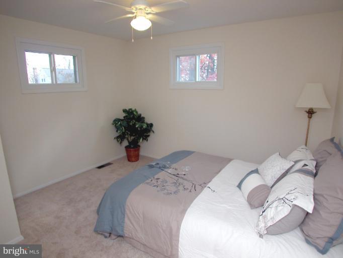 7920 Ridgely Oak Road Parkville, MD 21234 - Photo 7 of 13 a bedroom with a bed and a potted plant