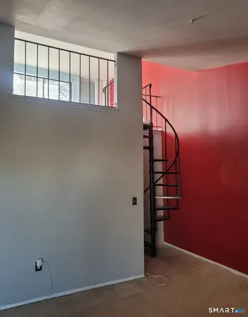 an empty room with windows & stairs