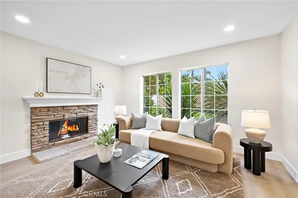 a living room with furniture a mirror and wooden floor