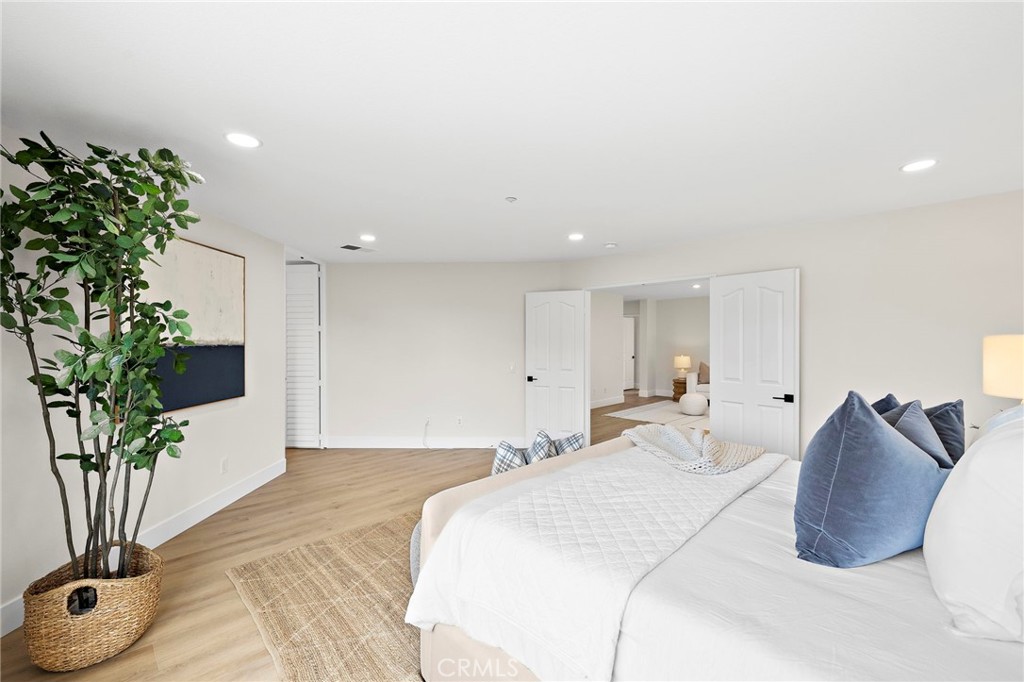 17 Rhode Island Irvine, CA 92606 - Photo 47 of 62 a spacious bedroom with a bed and a potted plant