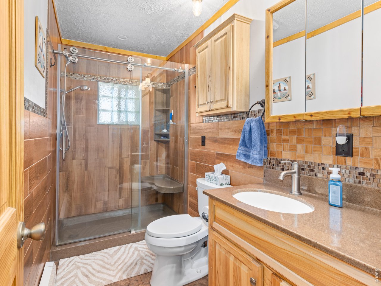 1817 Ranch Circle Estes Park, CO 80517 - Photo 19 of 36 Main bathroom featuring a Corian countertop and Hickory cabinets