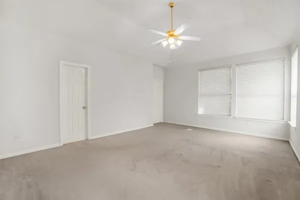 a bedroom with a bed a lamp on desk and a window