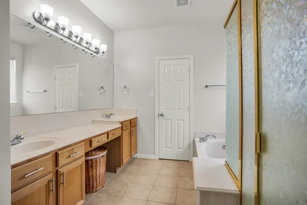 a spacious bathroom with a double vanity sink and a mirror