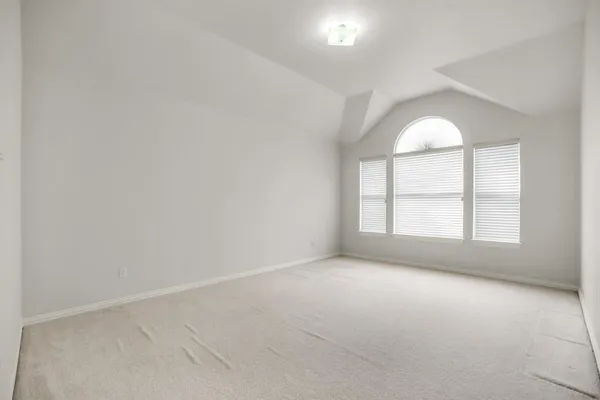 a view of a livingroom with a dinning space and windows