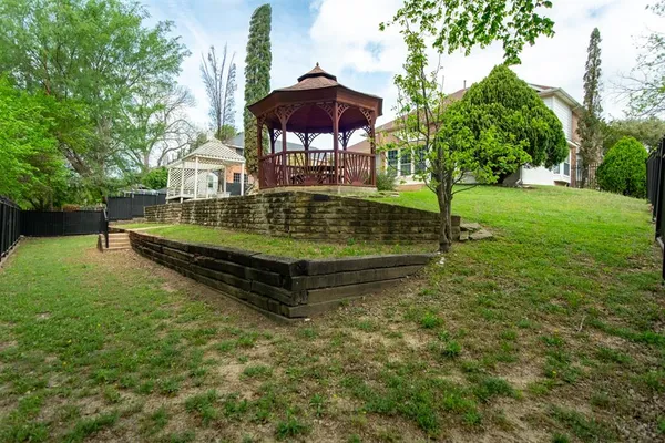 a view of a backyard with a garden and outdoor seating