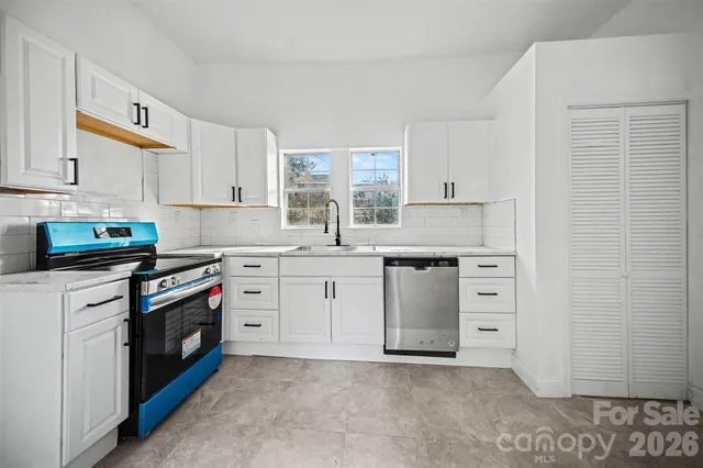 a kitchen with granite countertop white cabinets and white stainless steel appliances