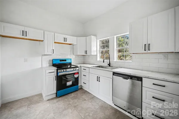 a kitchen with granite countertop white cabinets and stainless steel appliances